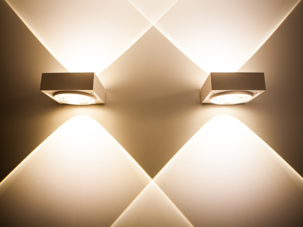 A woman in a beige kimono stands in a sunlit room